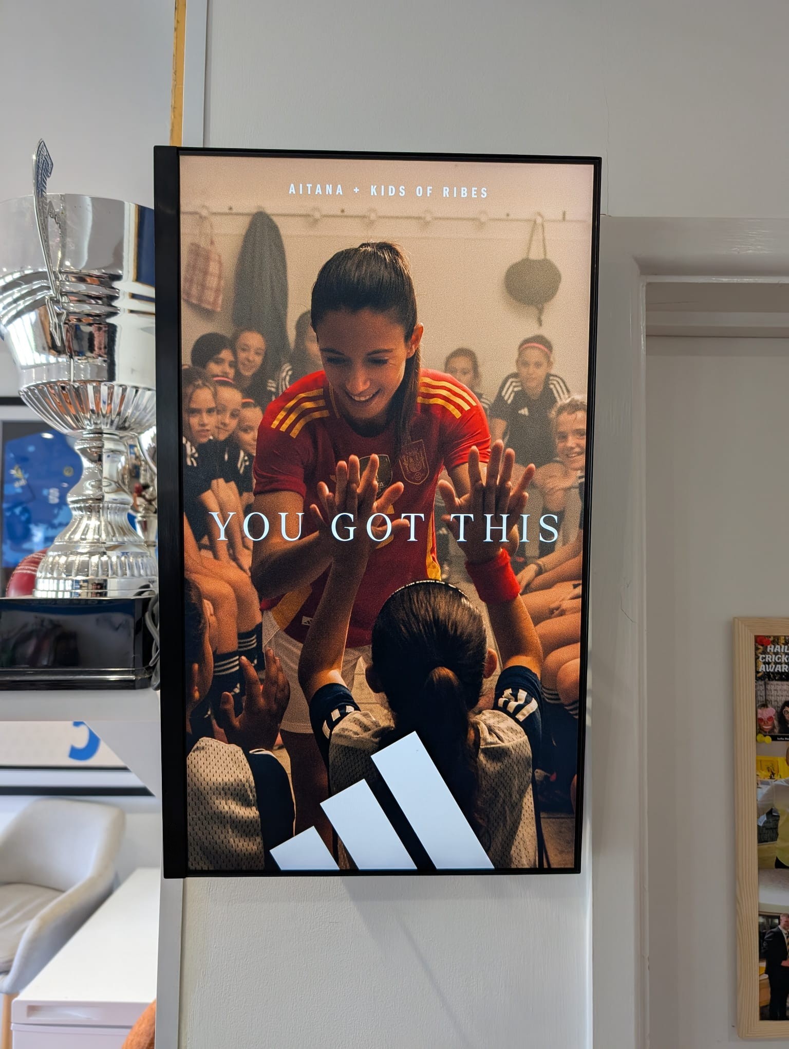 Close view of an Adidas women’s football campaign on a portrait Grassroot Media screen inside a football club.