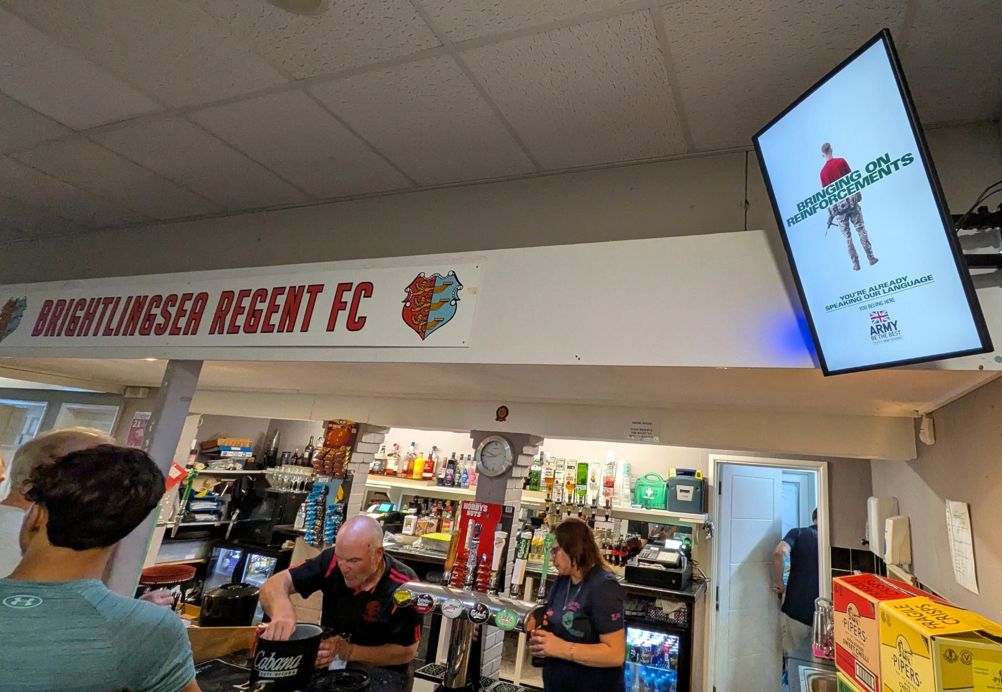 British Army campaign on a portrait Grassroot Media screen above the bar at Brightlingsea Regent Football Club.
