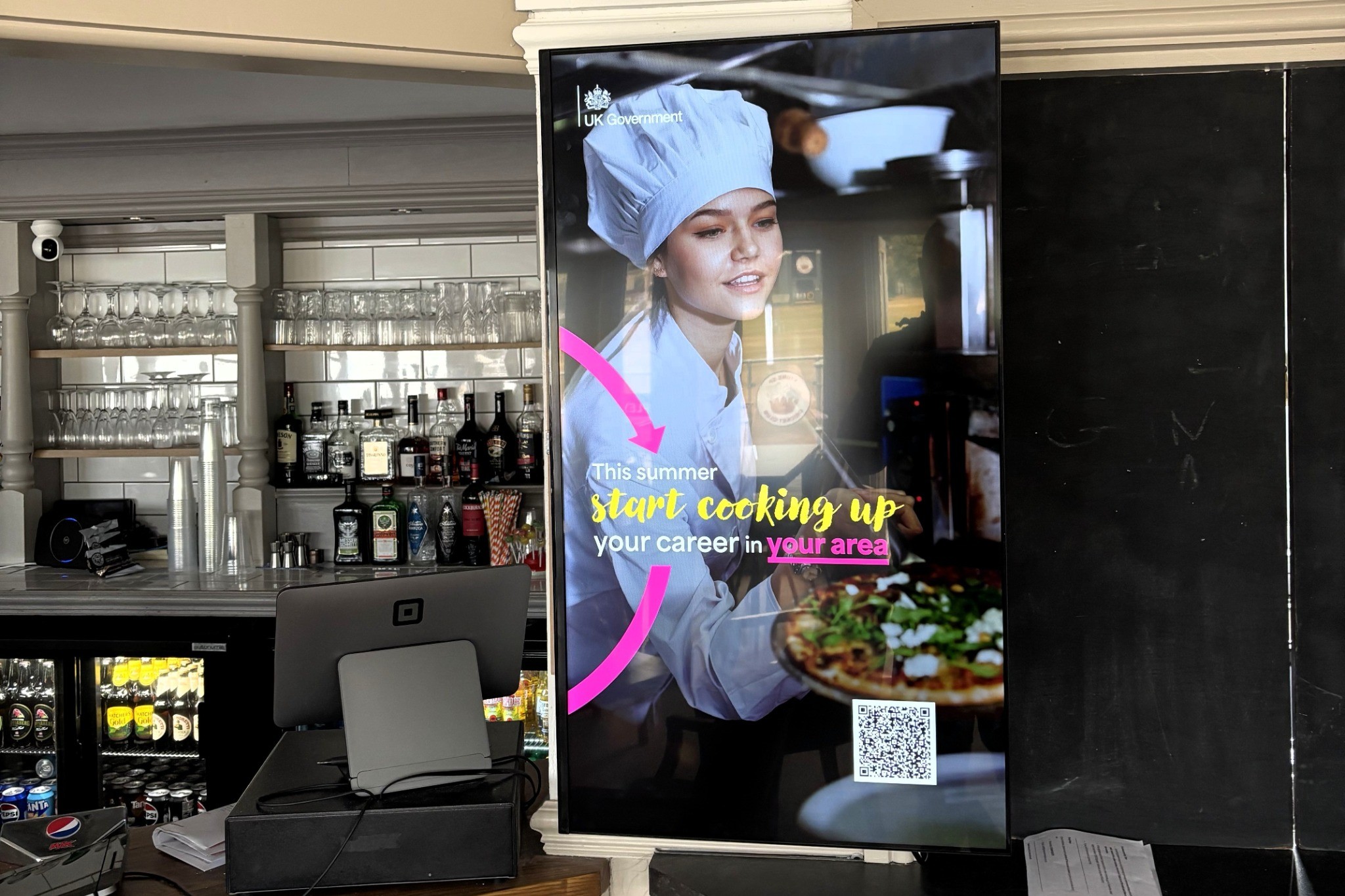UK Government careers campaign on a portrait Grassroot Media screen inside a rugby clubhouse bar.