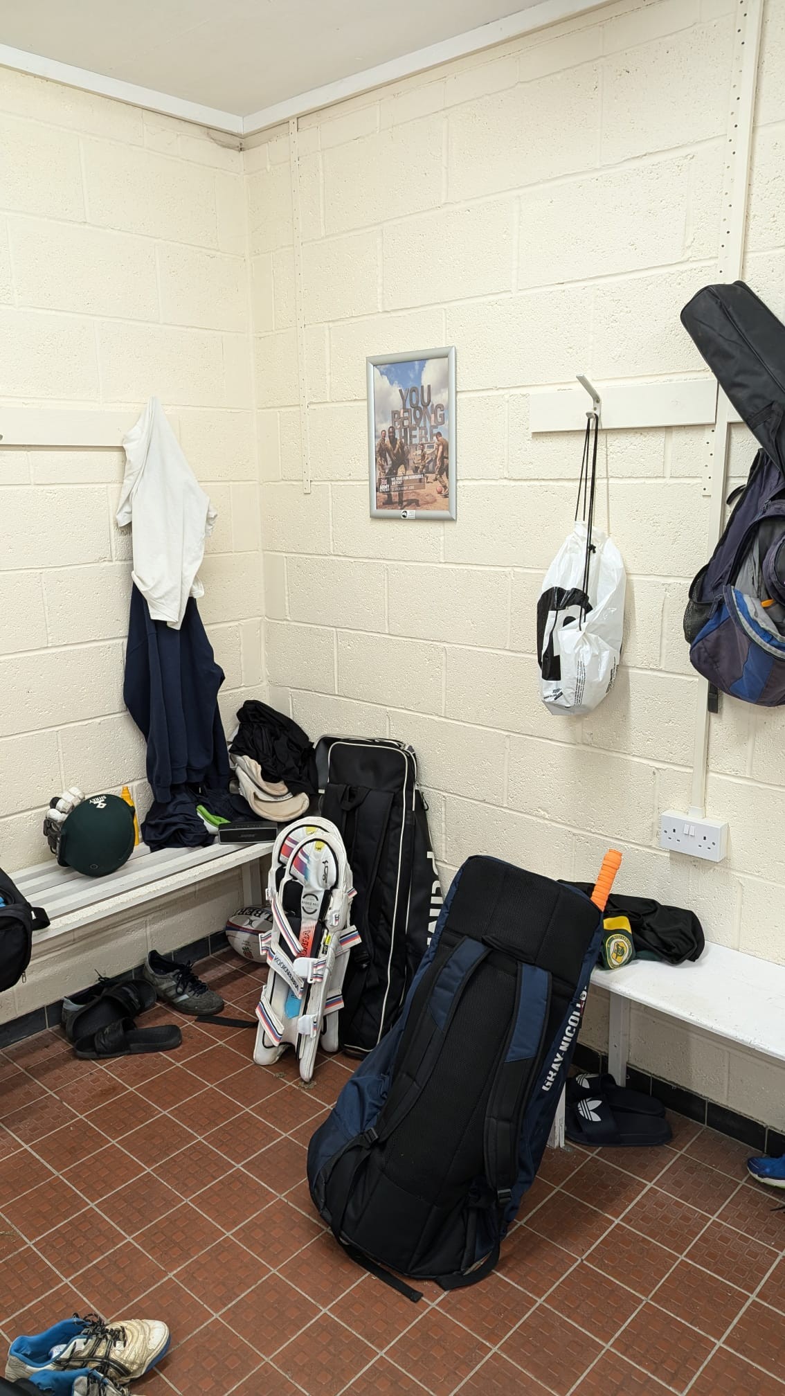 British Army recruitment campaign poster displayed in a cricket club changing room alongside players’ kit.