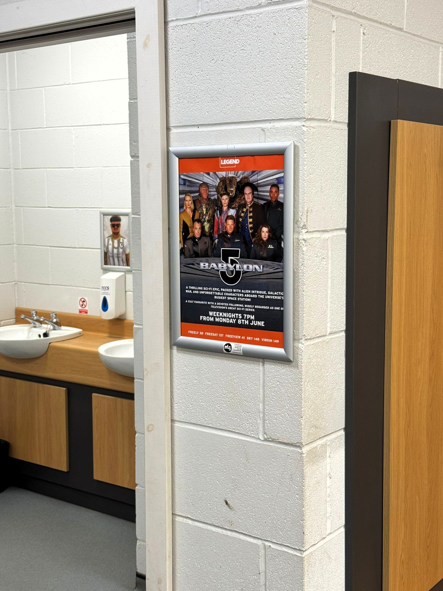 LEGEND television campaign poster displayed in a cricket club changing and washroom area.