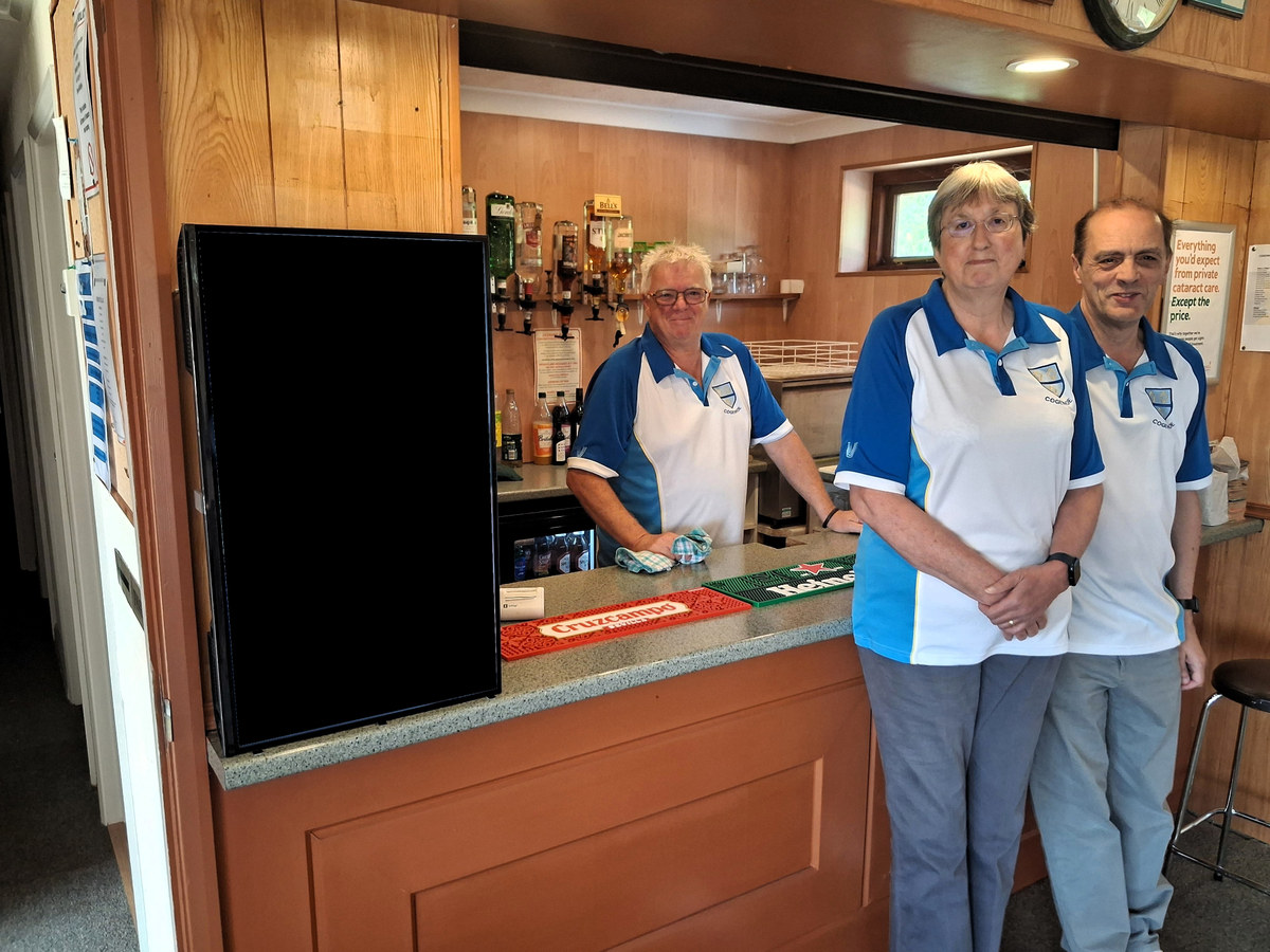 Bowls clubhouse bar showing members and the real environment around a portrait digital screen.