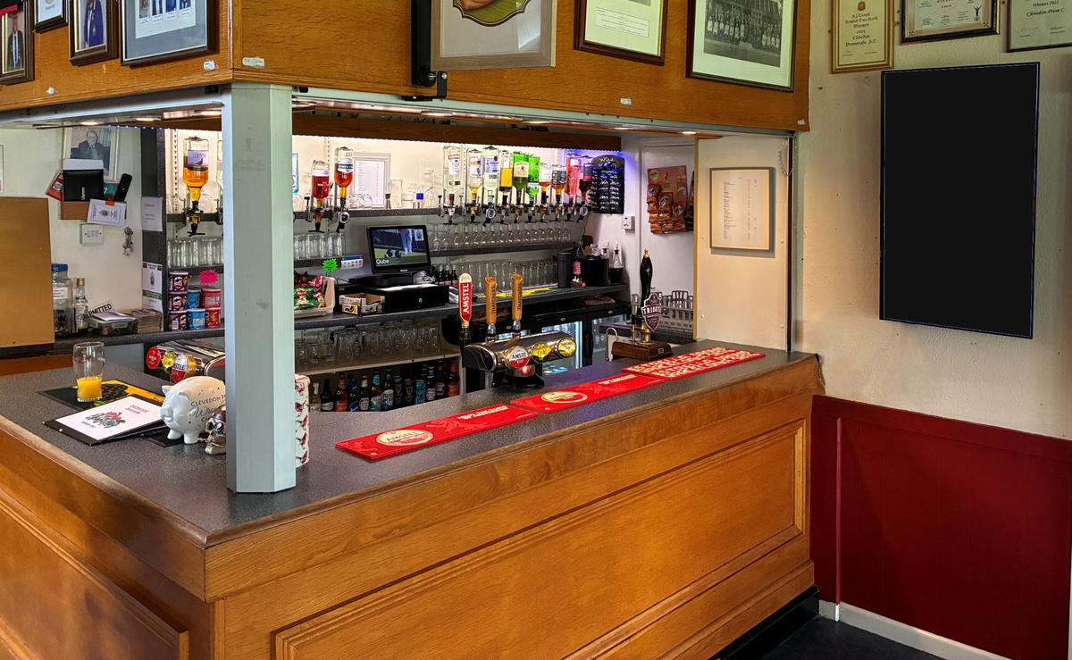 Cricket clubhouse and bar showing the real environment around a portrait digital screen.