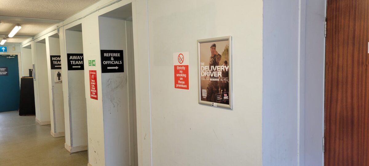 an army recruitment poster in a grassroots rugby club clubhouse corridor