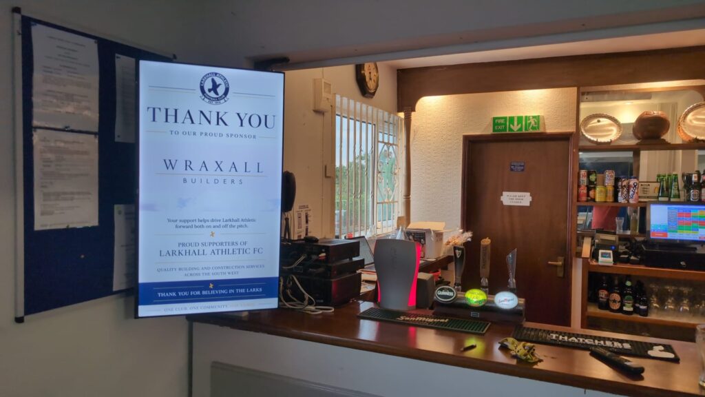 Larkhall Athletic FC digital screen in the clubhouse bar displaying a sponsor thank you message.