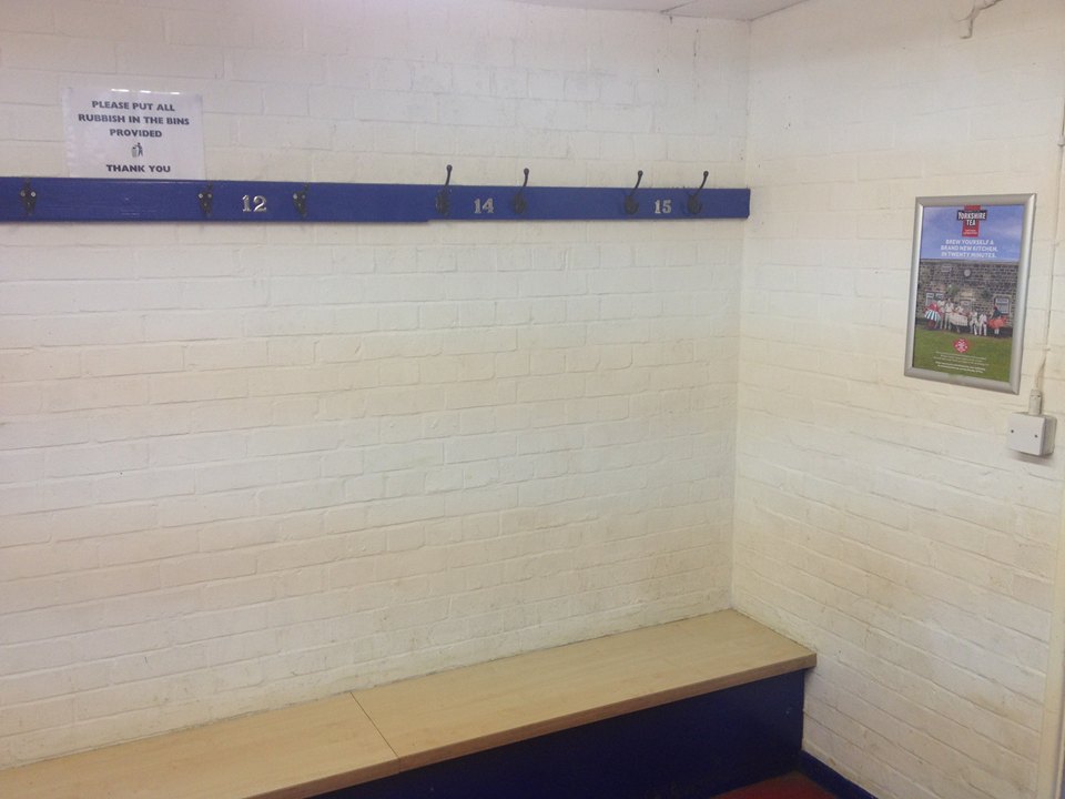 Yorkshire Tea advertising poster displayed on the wall of an otherwise uncluttered cricket changing room.