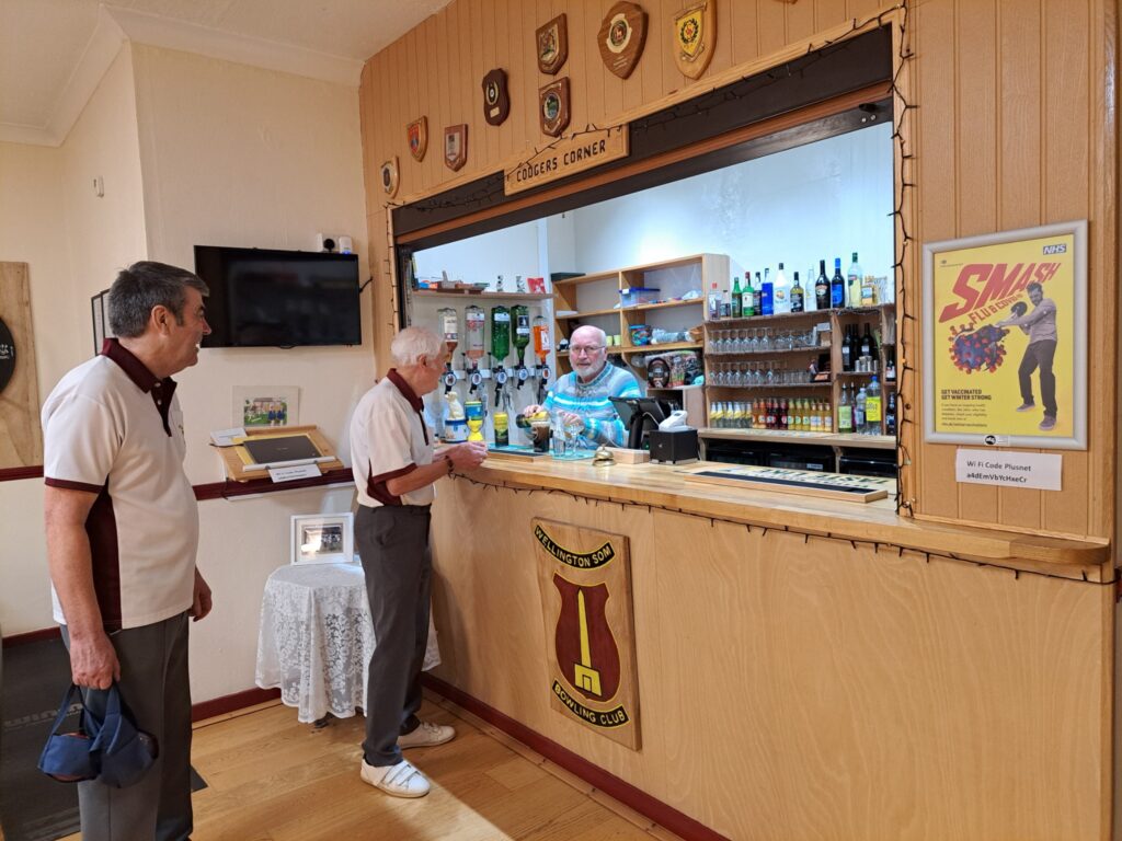 NHS public health campaign poster displayed beside the bar in a grassroots bowls clubhouse