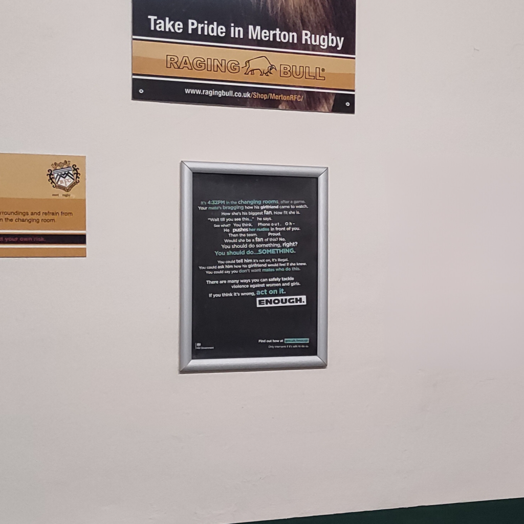 Government ENOUGH campaign poster displayed inside a grassroots rugby club changing-room area