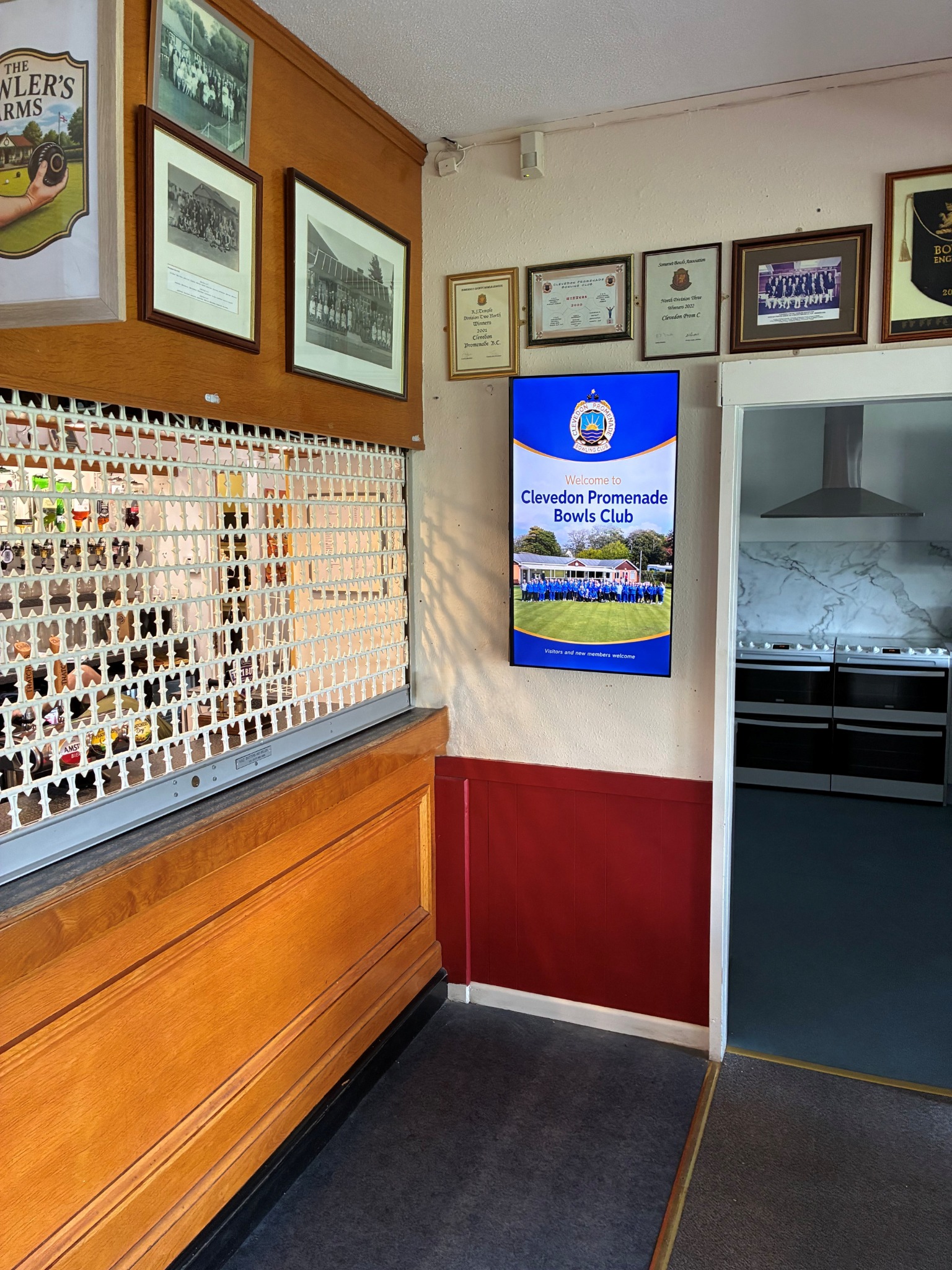 Grassroot Media digital screen displaying a Clevedon Promenade Bowls Club welcome message inside the clubhouse