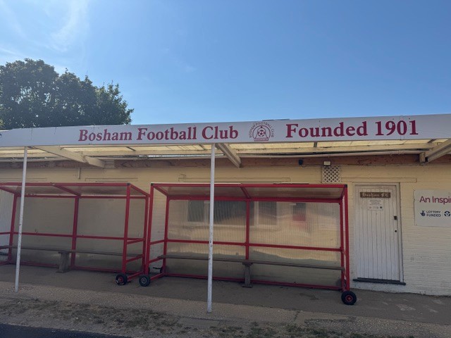 Bosham Football Club clubhouse frontage with the words Bosham Football Club Founded 1901 above the dugouts