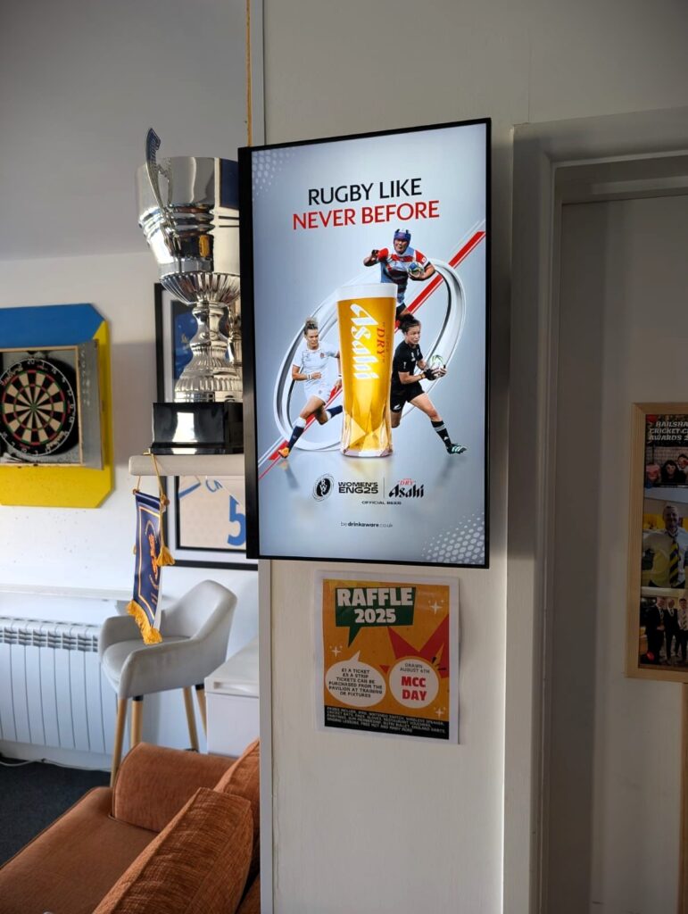 A Grassroot Media portrait digital screen at Hailsham Cricket Club showing Asahi women’s rugby creative