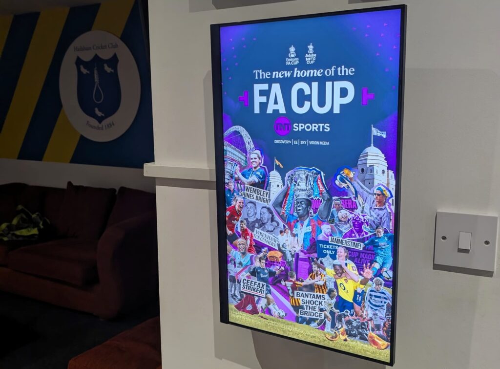 A Grassroot Media portrait digital screen at Hailsham Cricket Club displaying TNT Sports FA Cup creative