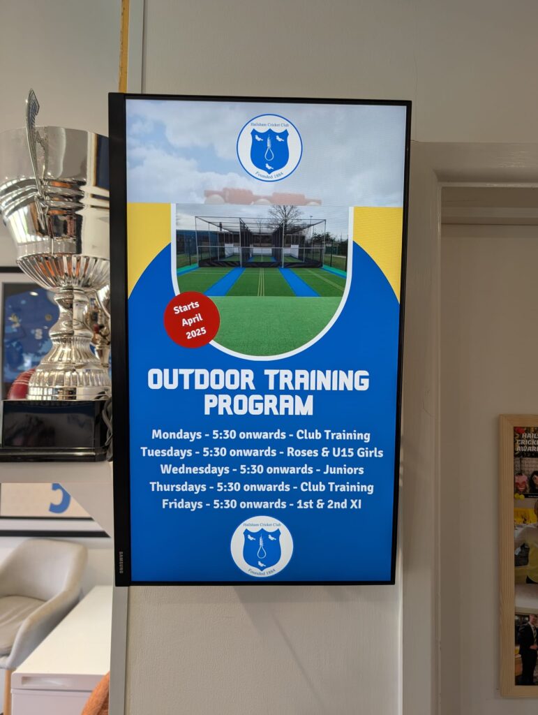 A Grassroot Media portrait digital screen at Hailsham Cricket Club displaying the club outdoor training programme
