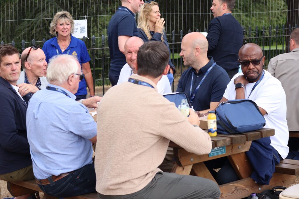 Hospitality guests talking together around a picnic table at the National Bowls Finals