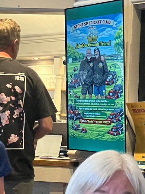 Portrait digital screen at Stone SP Cricket Club showing a club recruitment message for its grounds team