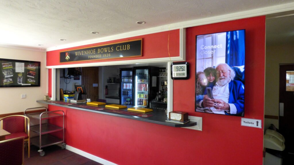 Doro advertising displayed on the portrait digital screen inside Wivenhoe Bowls Club