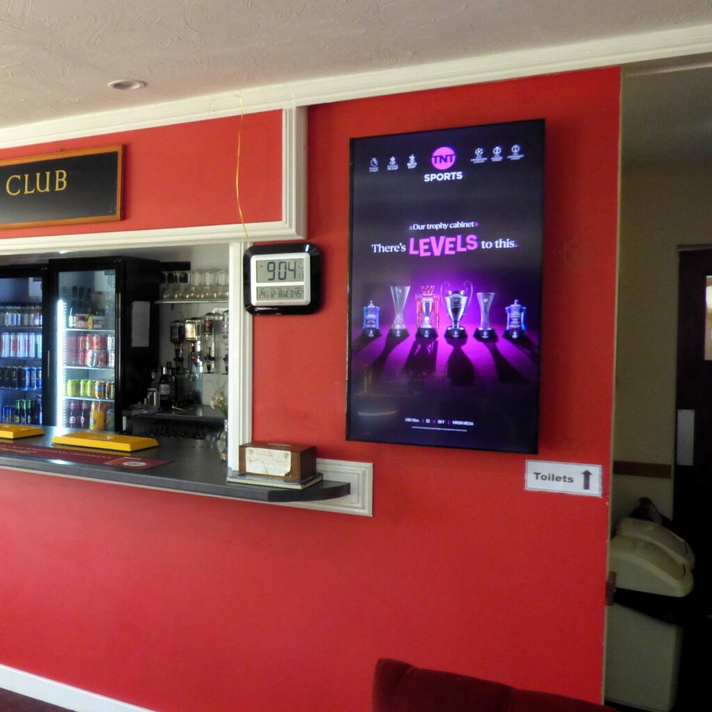 TNT Sports advertising displayed on the portrait Grassroot Media screen at Wivenhoe Bowls Club