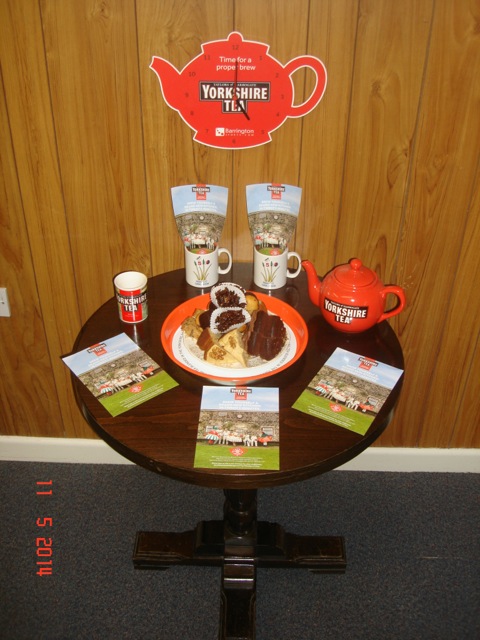 Yorkshire Tea leaflets, branded teapot, mugs and refreshments arranged on a clubhouse table
